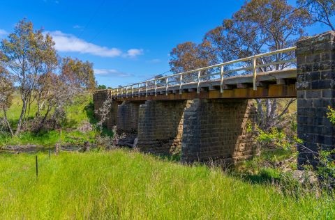 Stone bridge in a rural area with green grass 