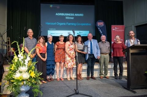Photo of ten people standing on a stage accepting an award