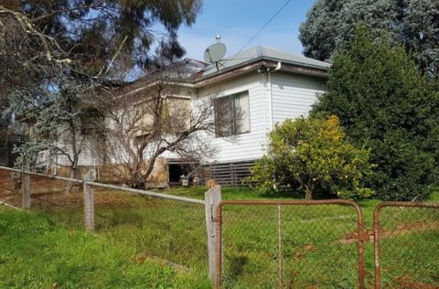 White weatherboard house on grassy property