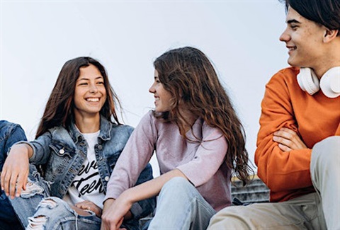Teenagers sitting together talking and laughing